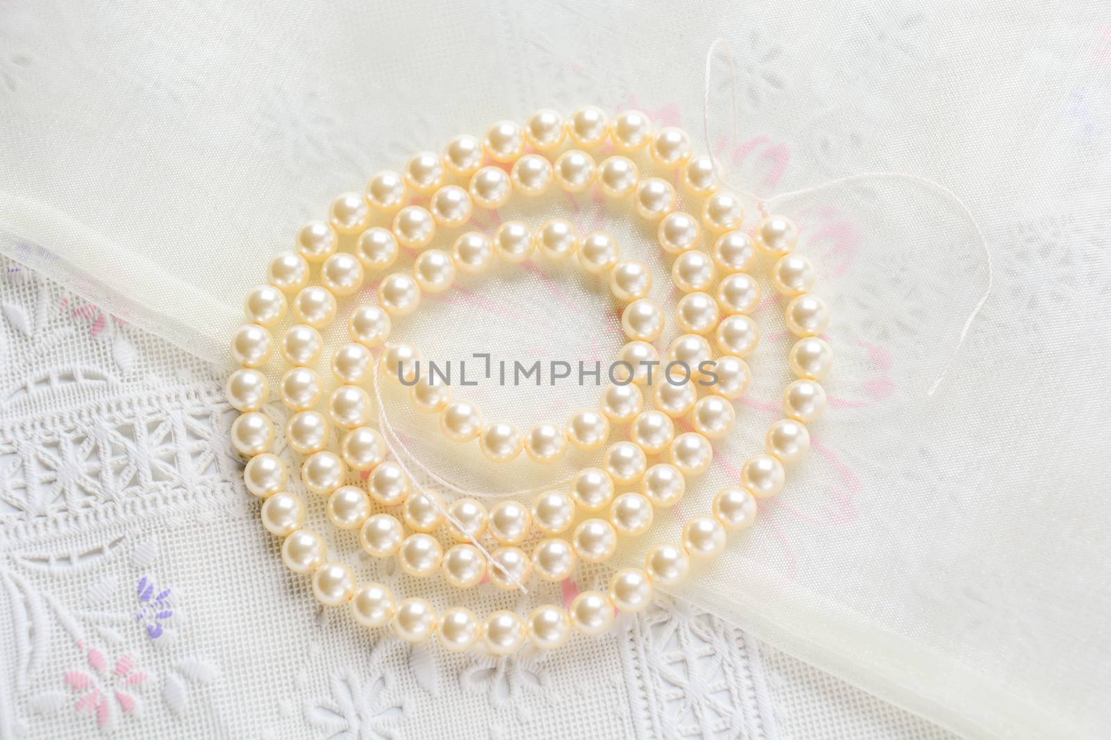 pearl necklace on white fabric background, Close up shot of glas by yuiyuize