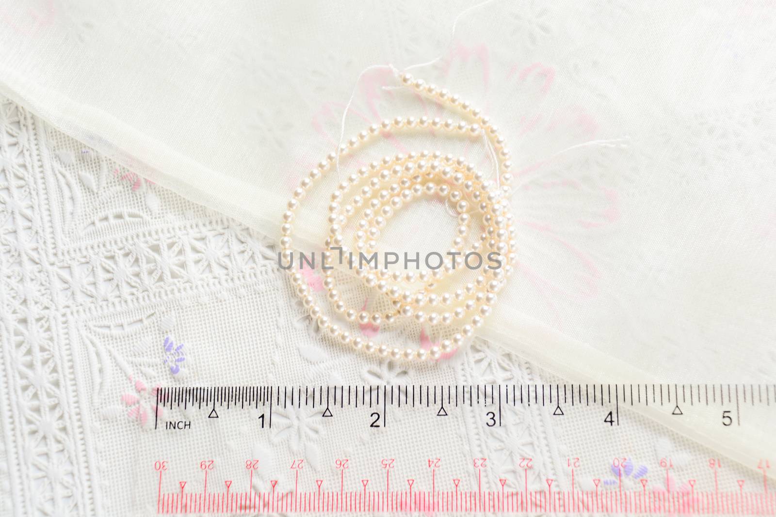 pearl necklace on white fabric background, Close up shot of glas by yuiyuize