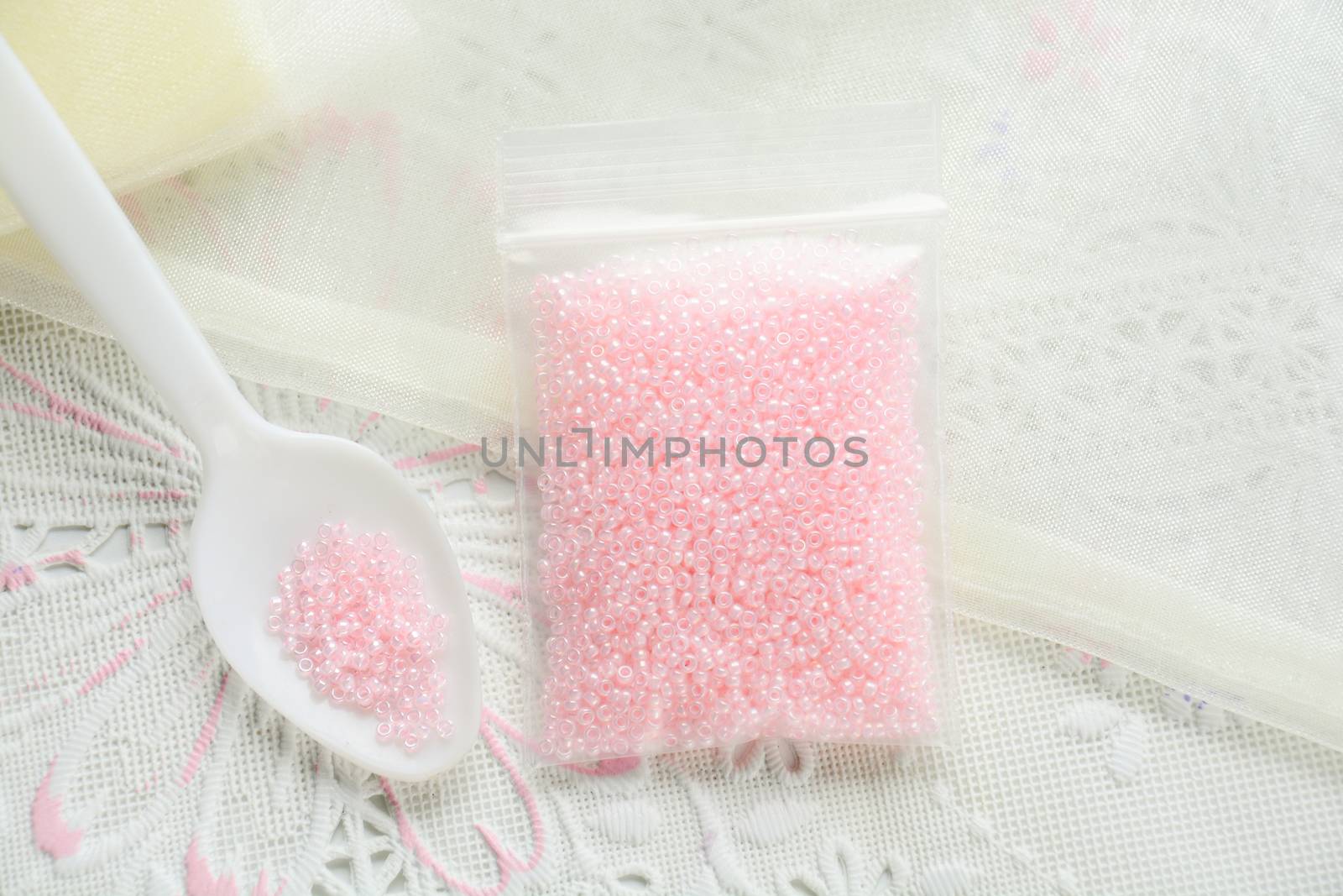 Colorful beads on white fabric surface. Various of shapes and co by yuiyuize