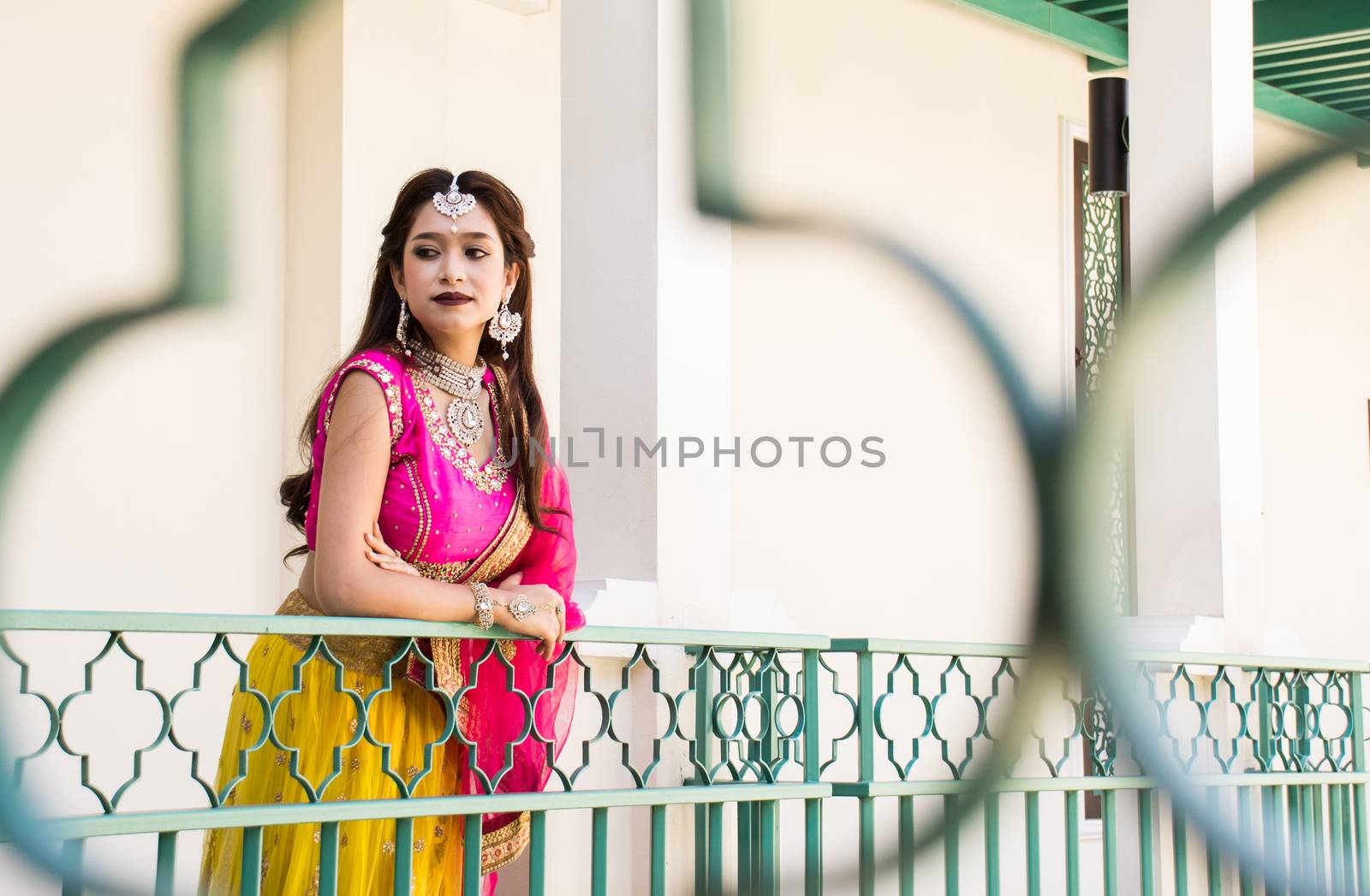 Pink and Yellow Indian Costume Beautiful Girl, face partially covered with saree. Portrait of Traditional woman in sari dress.
