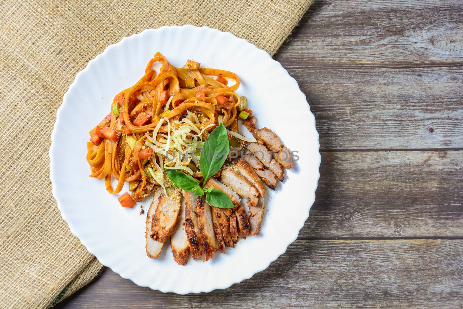 Steak meat with spaghetti and cheese on wood background.
