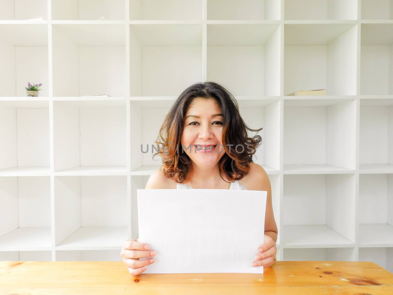 Attractive beautiful woman holding blank white paper.
