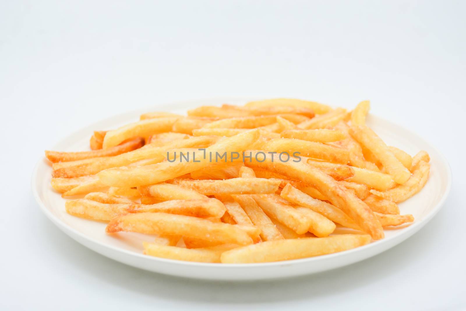 French fries on white dish and white background.