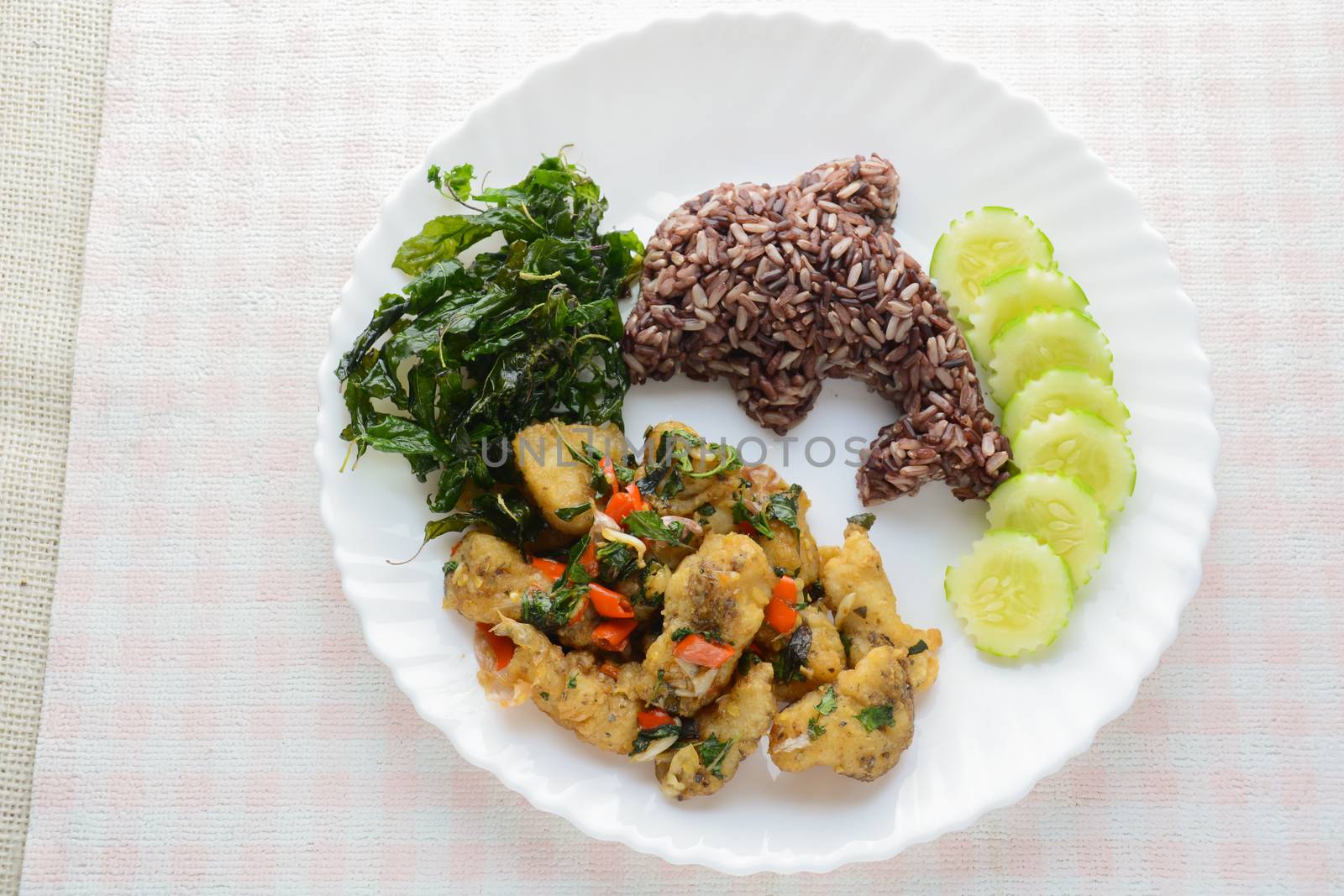 Stir fried fish with chili and basil, served with steamed rice and cucumber, hot and spicy dish.