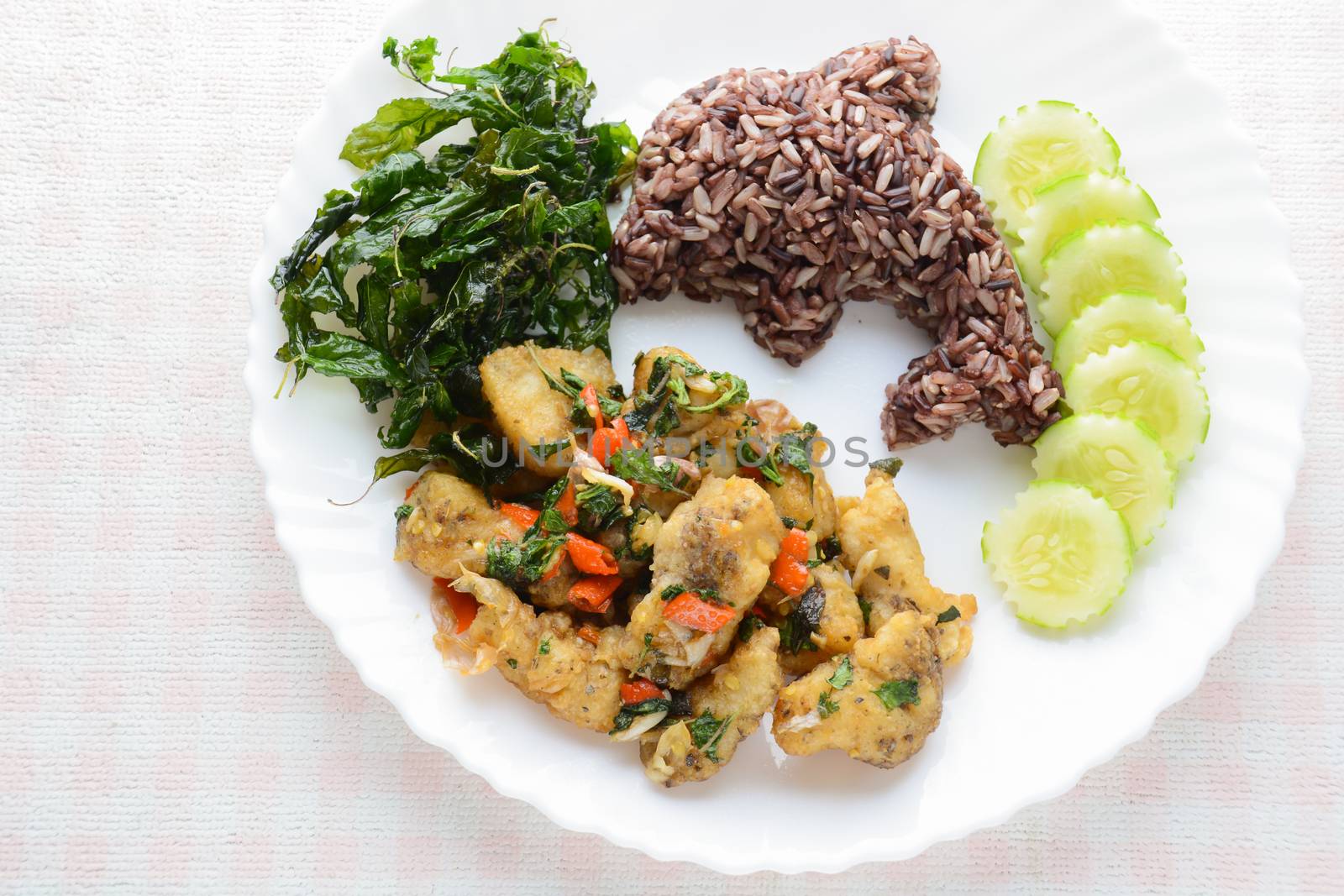 Stir fried fish with chili and basil, served with steamed rice and cucumber, hot and spicy dish.