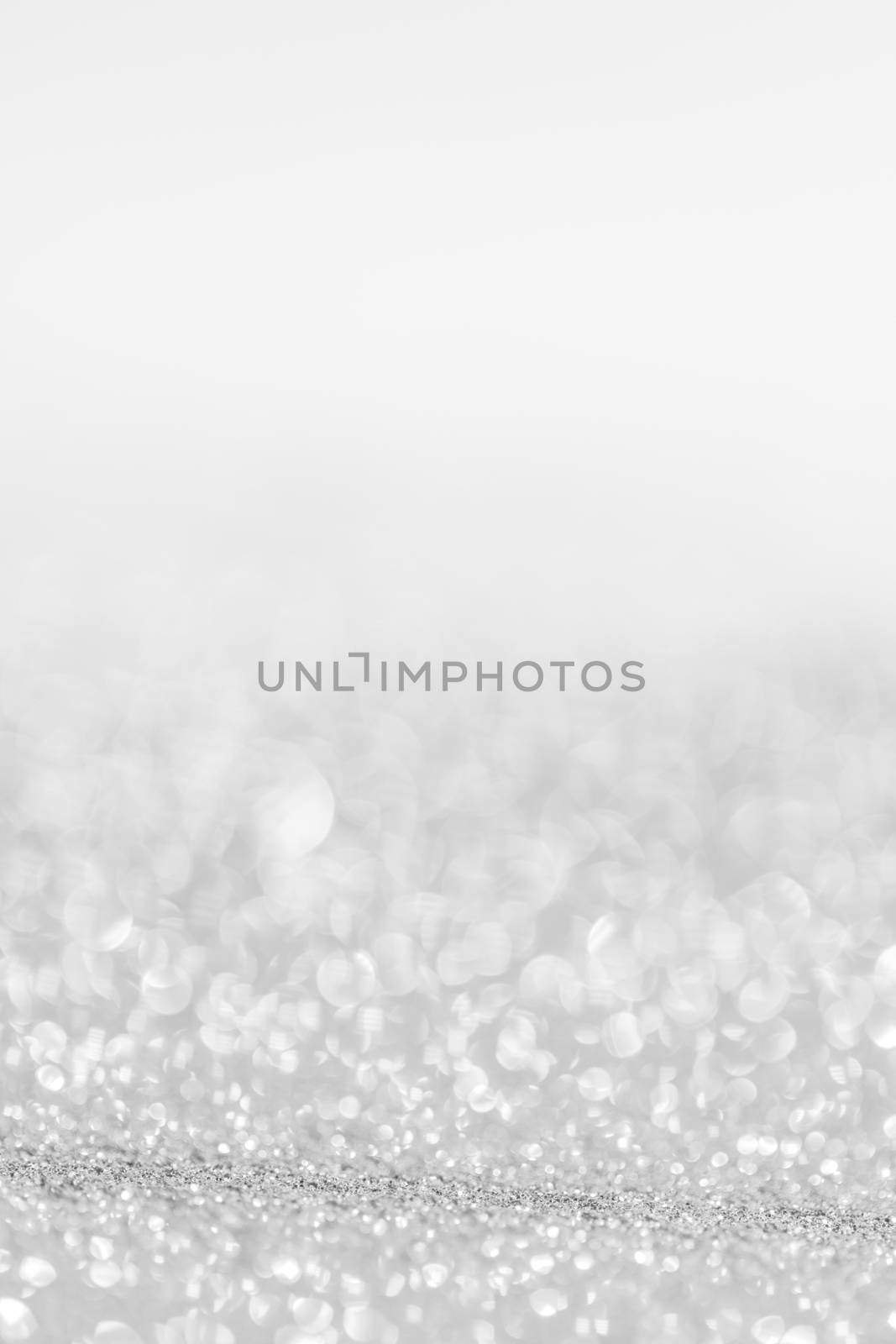 Silver festive glitter background with defocused lights