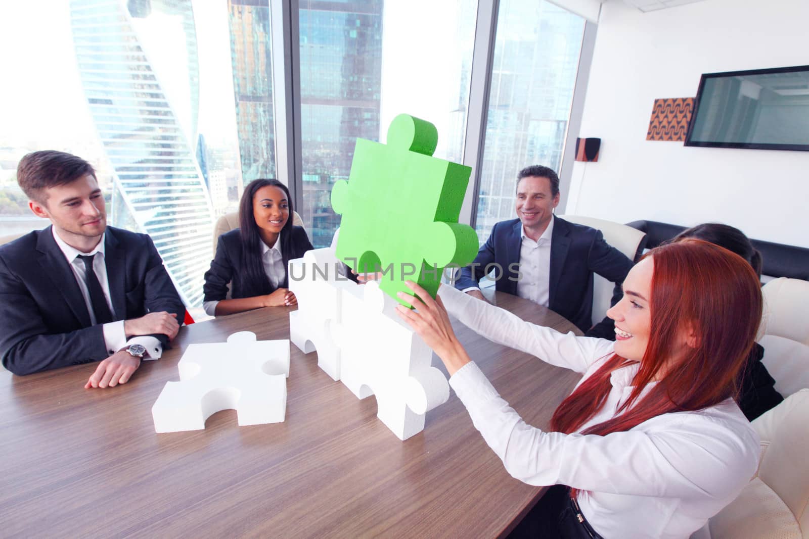 Group of business people assembling jigsaw puzzle and represent team support and help concept in office