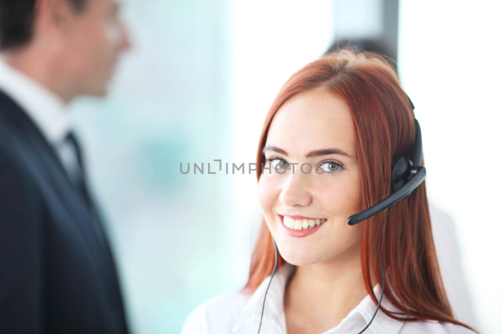 Portrait of a smiling creative businesswoman with earpiece in of by ALotOfPeople