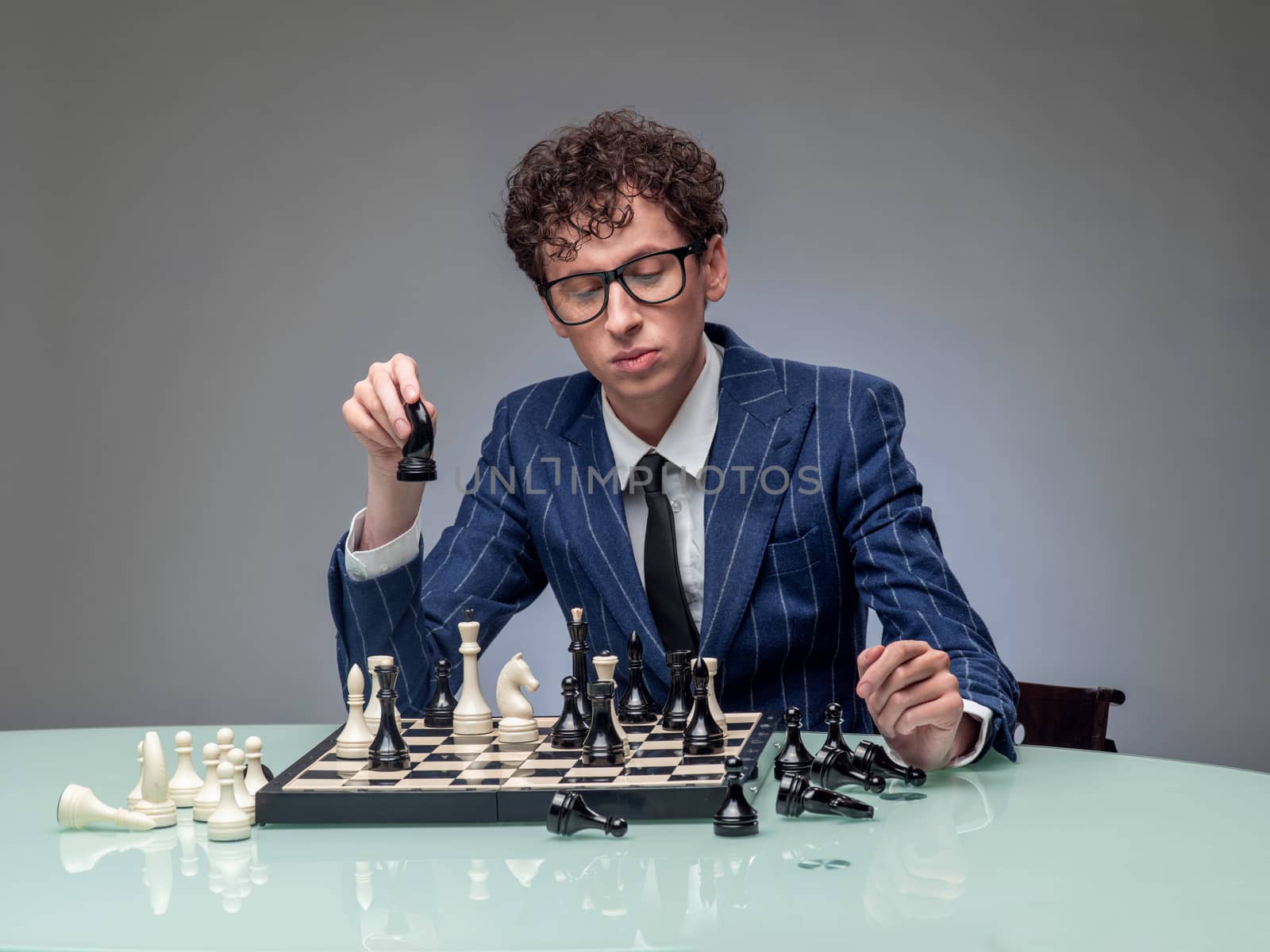 Studio portrait of successful business man playing chess