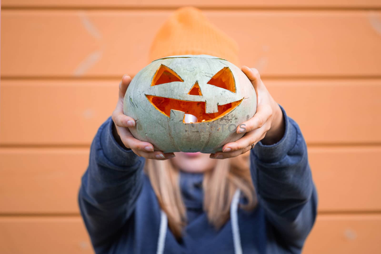 Woman holding Halloween pumpkin by destillat