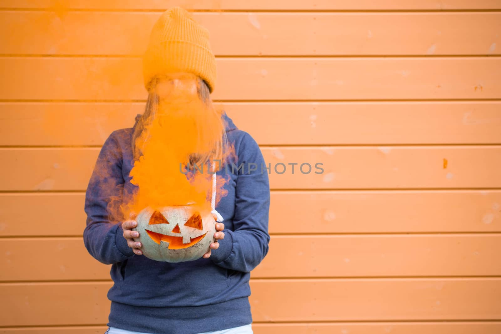Woman holding Halloween pumpkin by destillat
