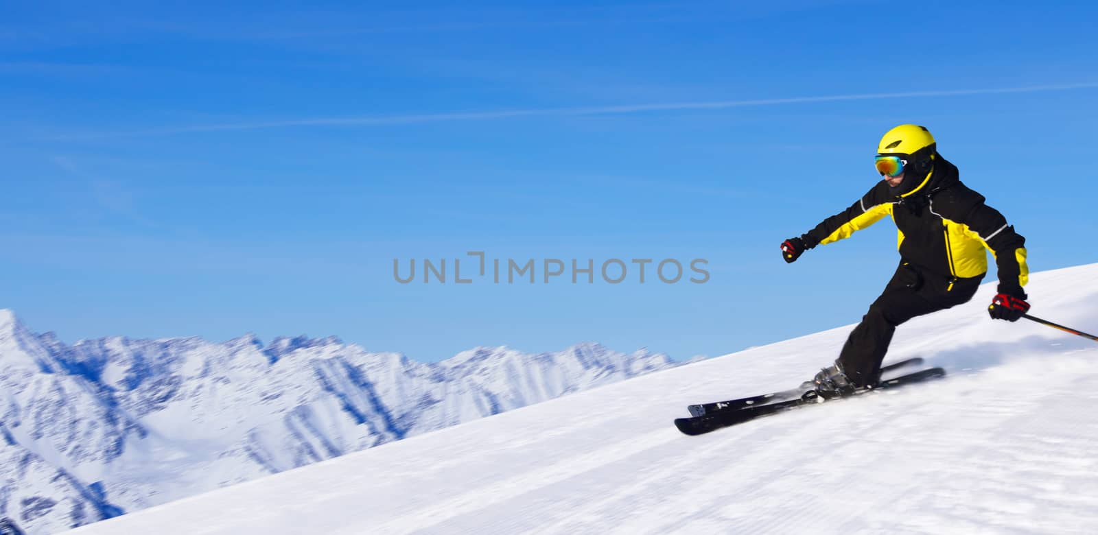 Professional alpine skier skiing downhill in high mountains of Alps