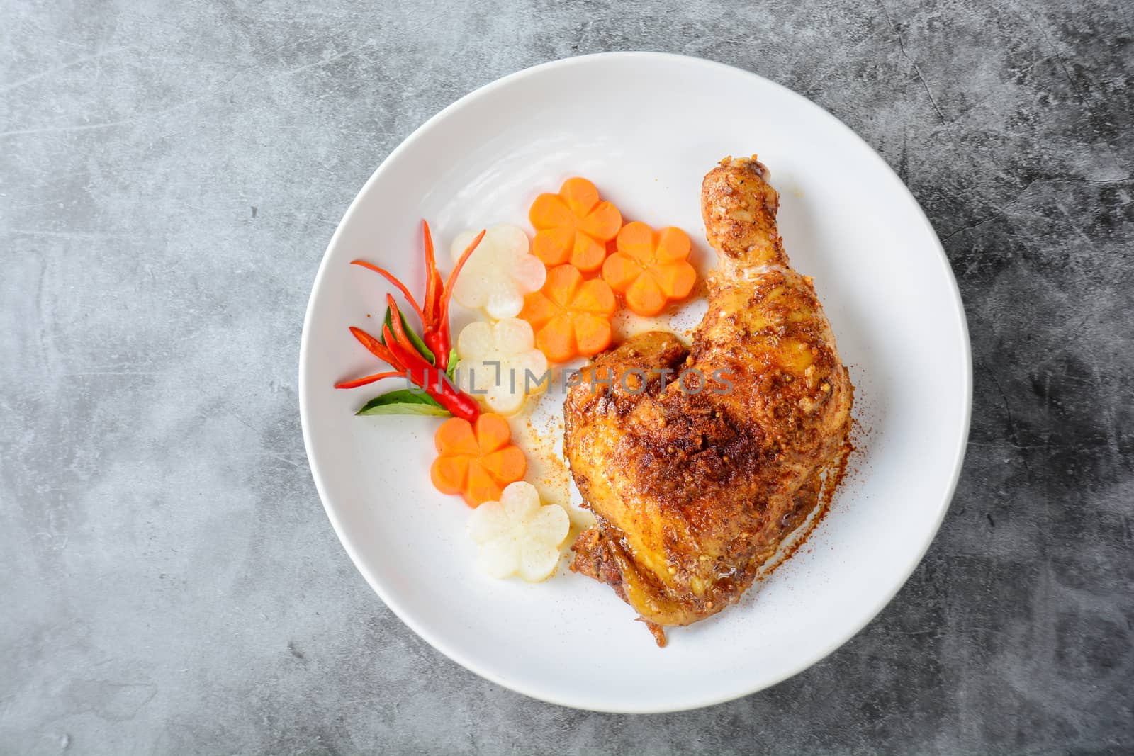 Hot and spicy baked chicken on white plate
