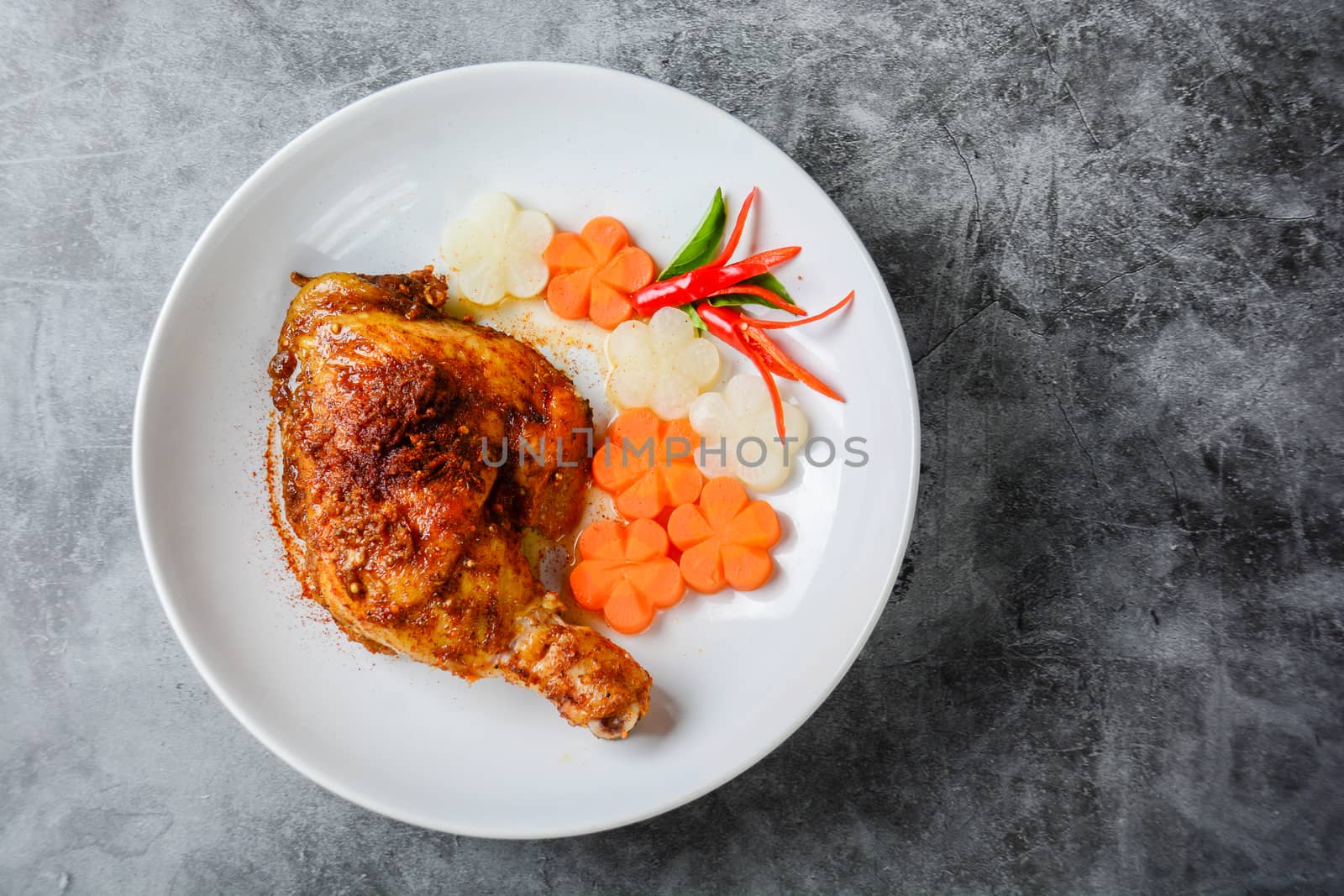 Hot and spicy baked chicken on white plate
