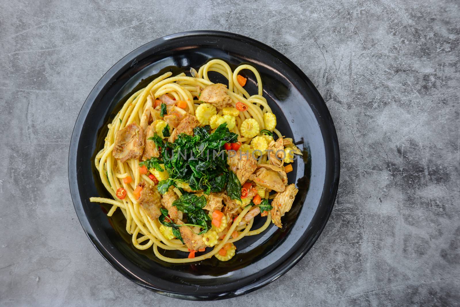 Hot and spicy chicken spaghetti, topping with crispy sweet basil and sliced baby corn
