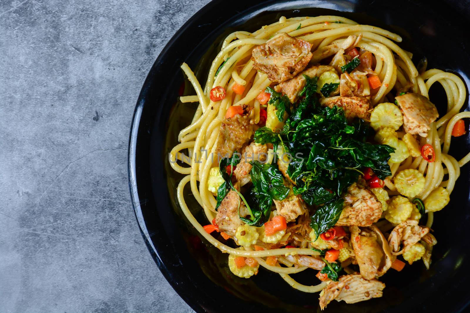 Hot and spicy chicken spaghetti, topping with crispy sweet basil and sliced baby corn
