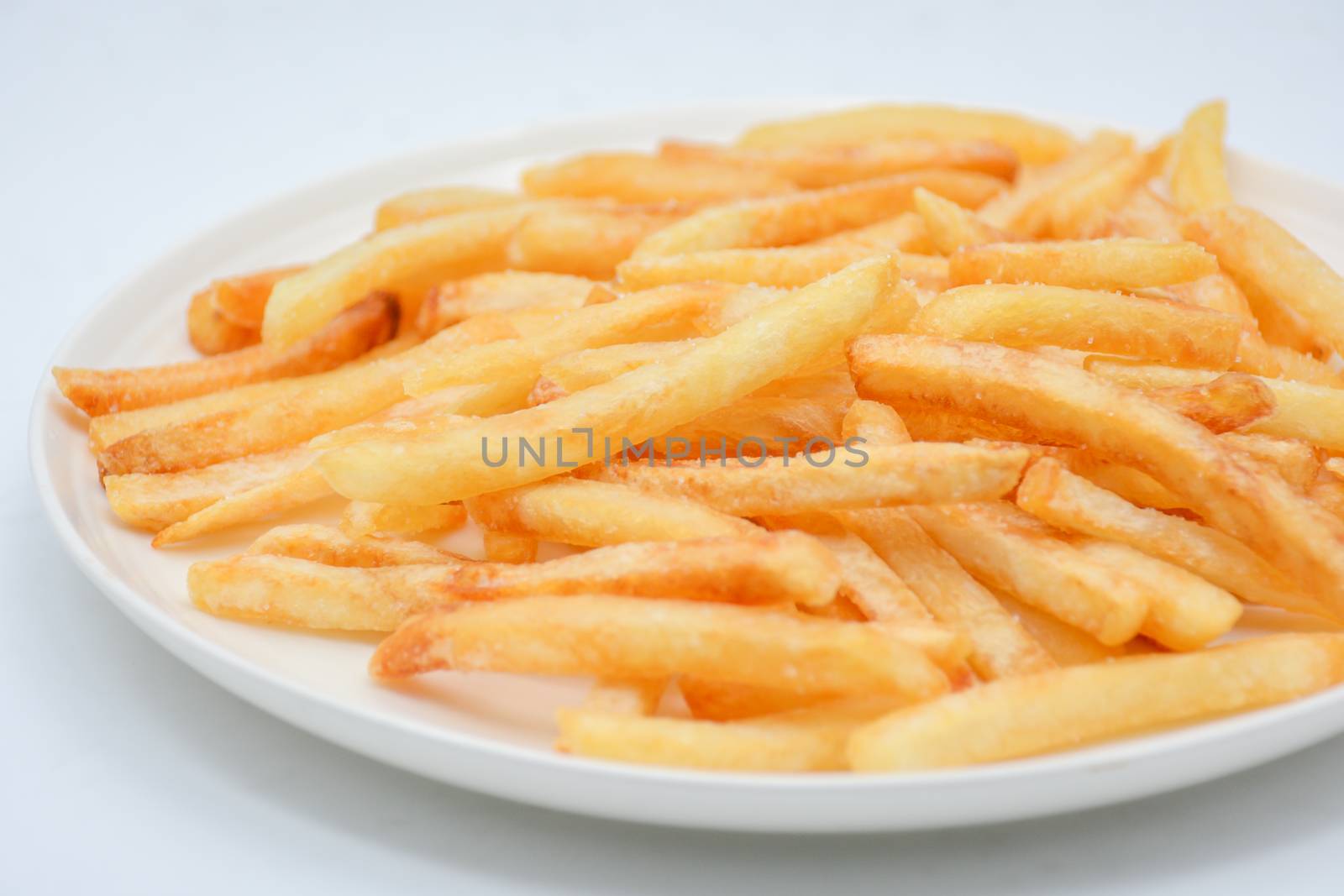 French fries on white dish and white background.