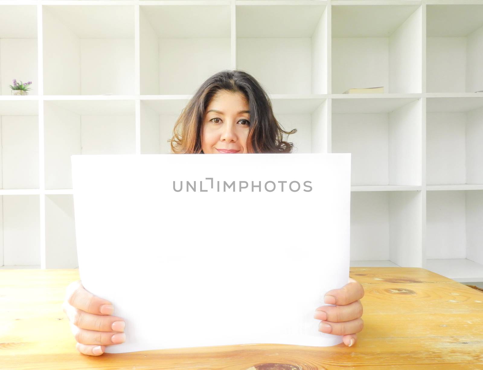 Attractive beautiful woman holding blank white paper.
