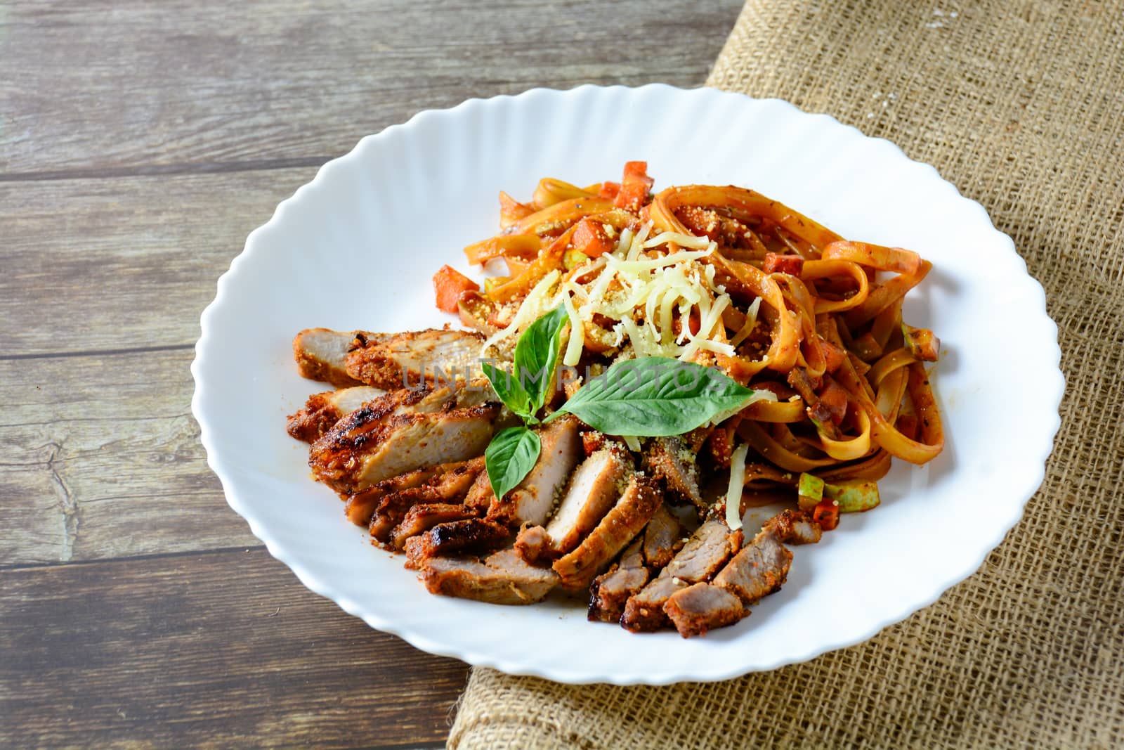 Steak meat with spaghetti and cheese on wood background.
