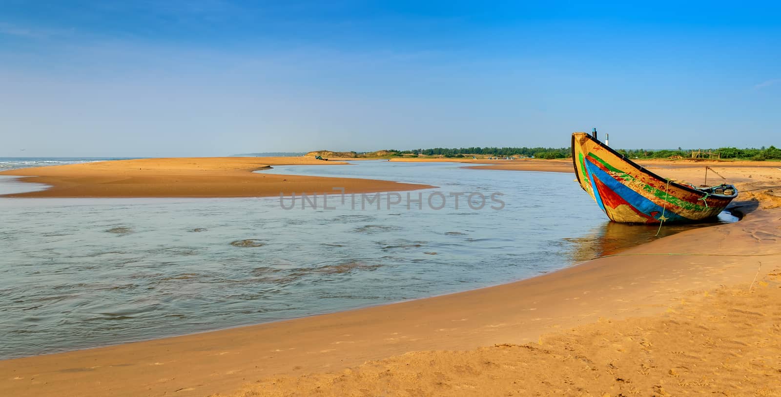 Traditional colorful fishing boat anchored at the confluence of Mahendra Tanaya river and Bay of Bengal, copy space
