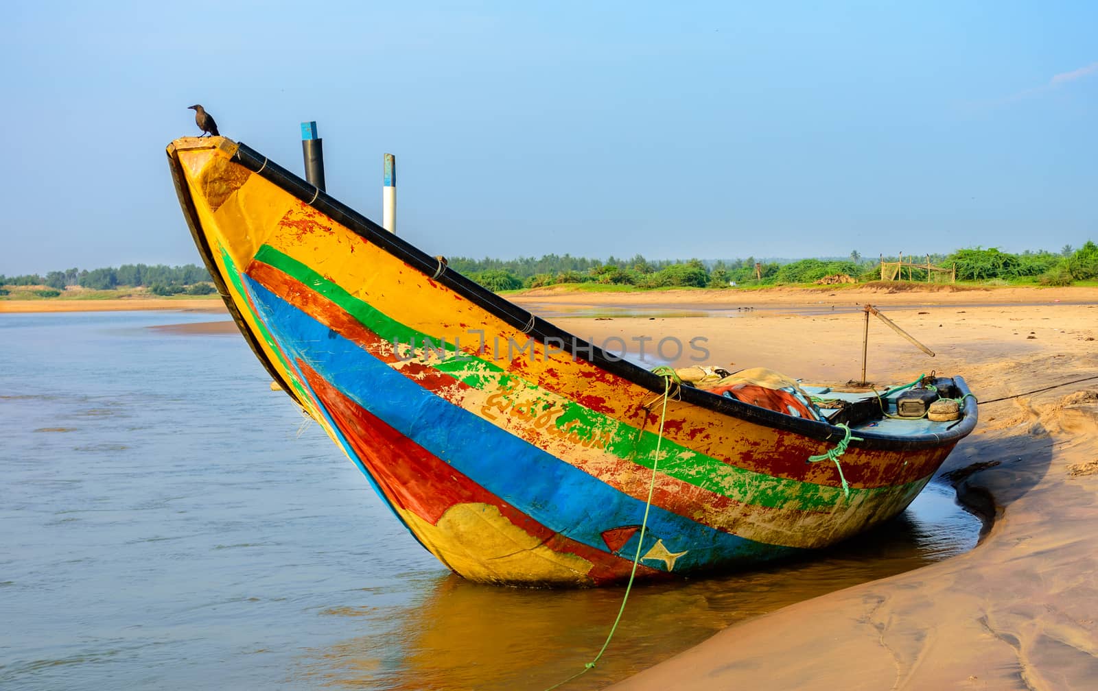 Traditional colorful fishing boat anchored at the confluence of Mahendra Tanaya river and Bay of Bengal, copy space