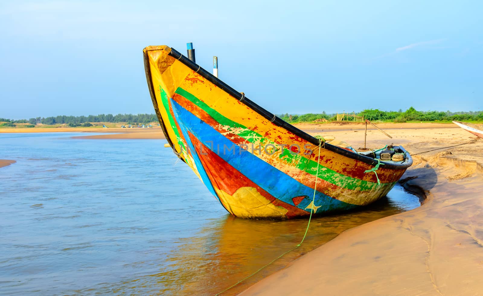 Traditional colorful fishing boat anchored at the confluence of Mahendra Tanaya river and Bay of Bengal, copy space