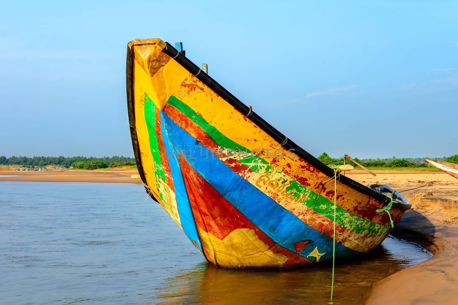 Traditional colorful fishing boat anchored at the confluence of Mahendra Tanaya river and Bay of Bengal, copy space