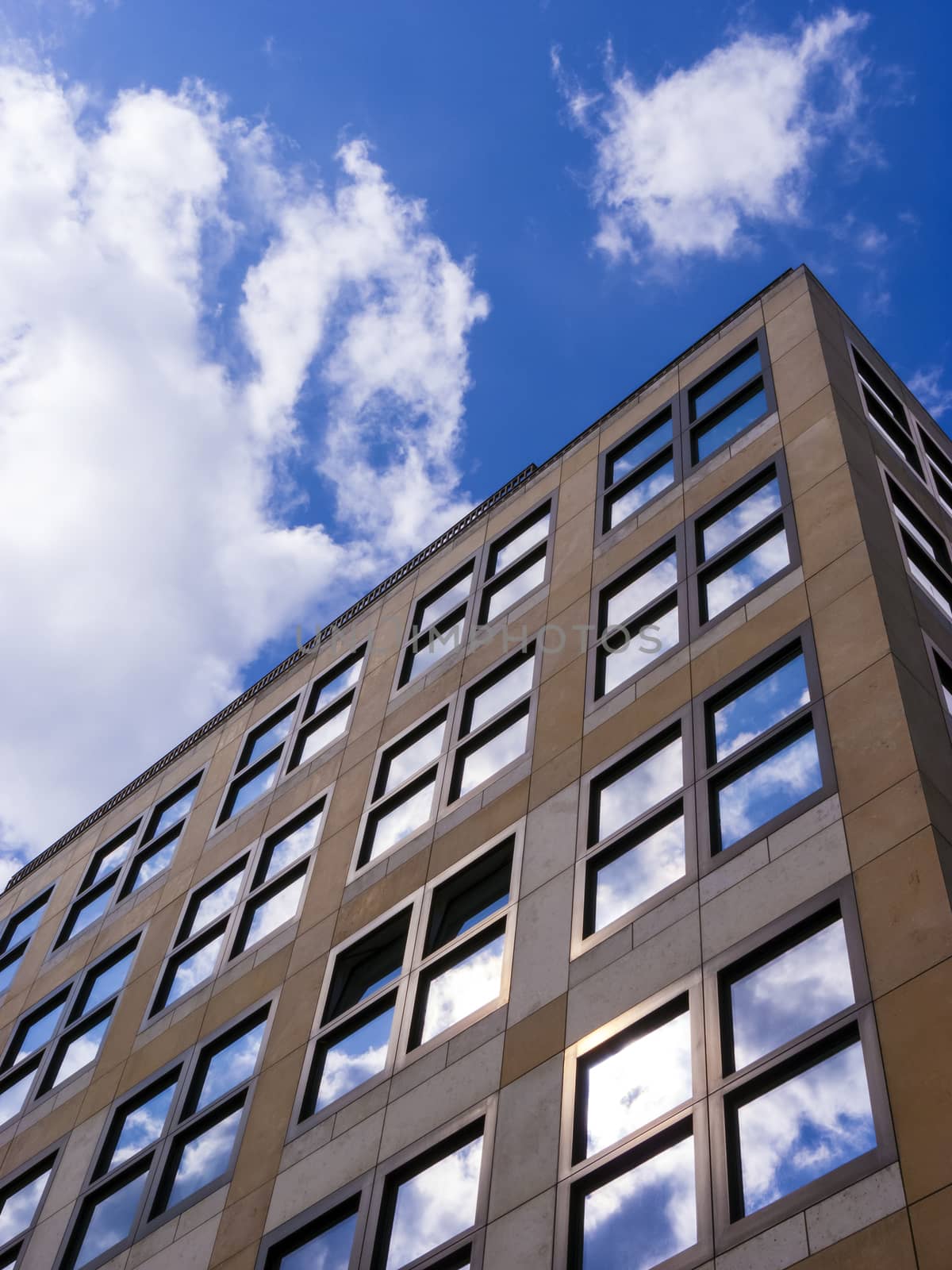 Cloudy sky reflected in the glass wall of a high building.