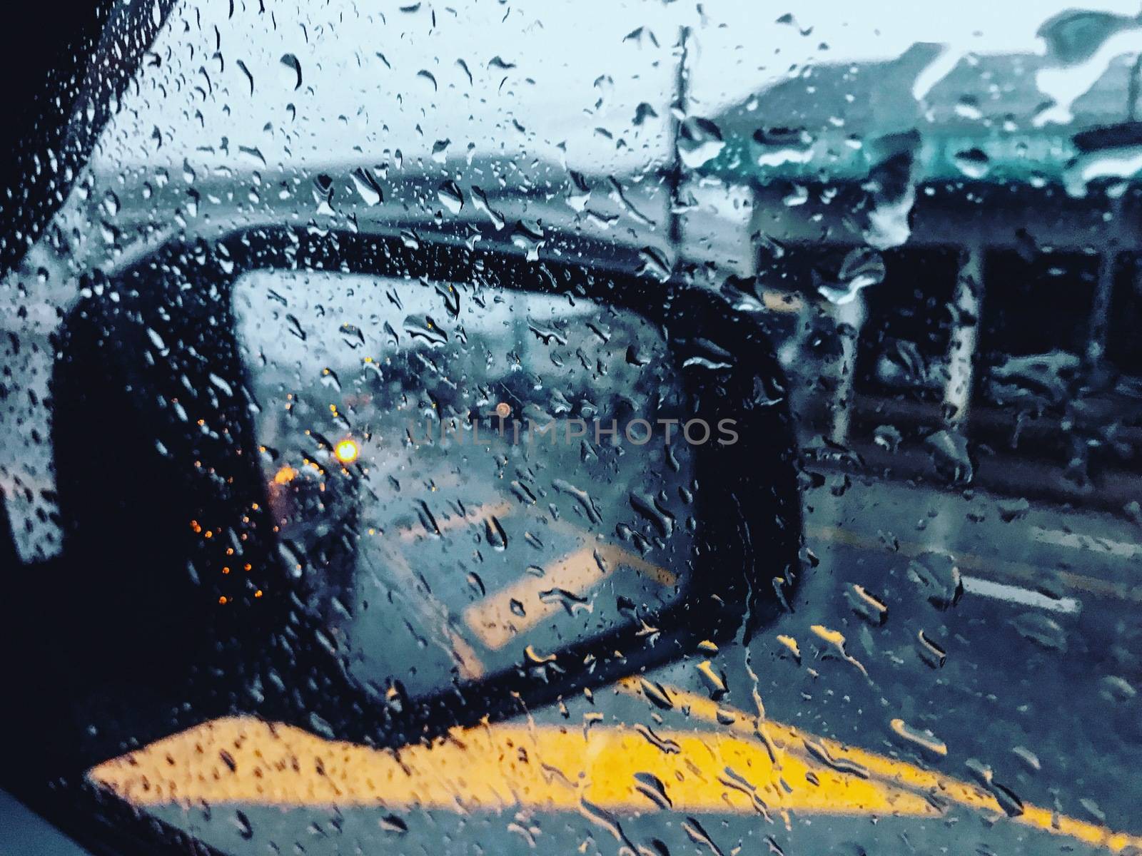 Drops of rain fell on the glass of the car, there was a blurry scene. by aekgasit