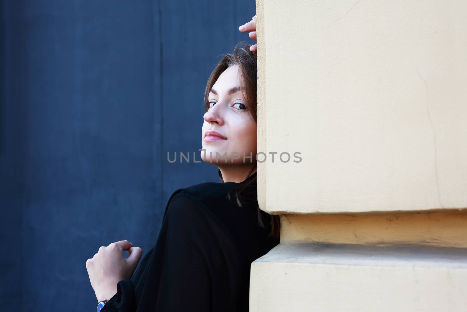 Beautiful young woman against old building wall