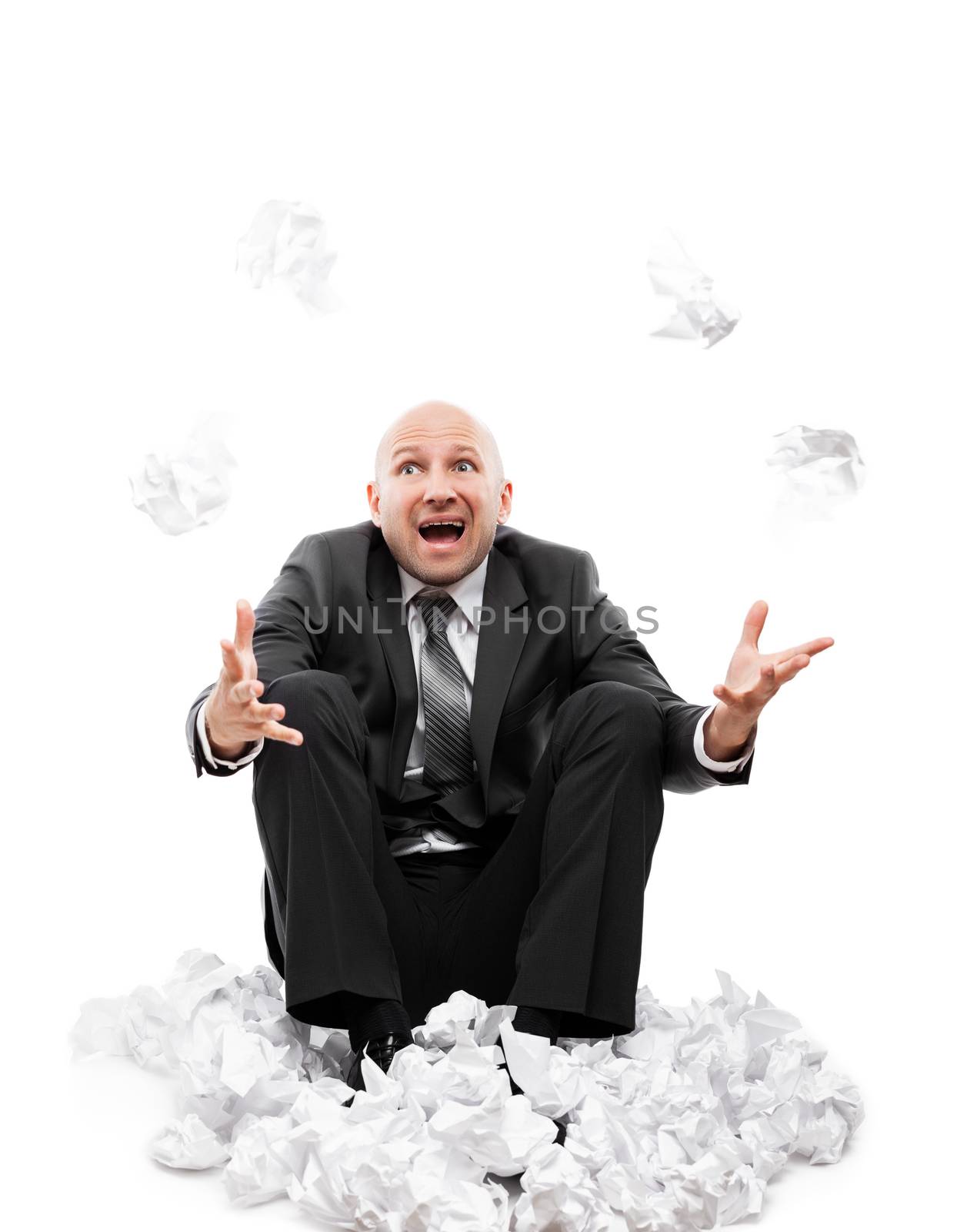 Business problems and failure at work concept - unhappy tired or stressed businessman in depression sitting down floor hand throwing crumpled torn paper document white isolated