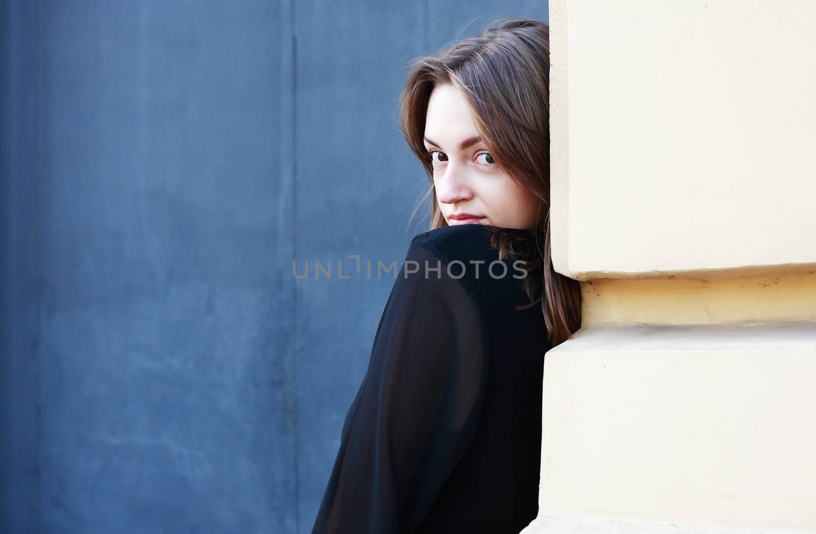 Beautiful young woman against old building wall