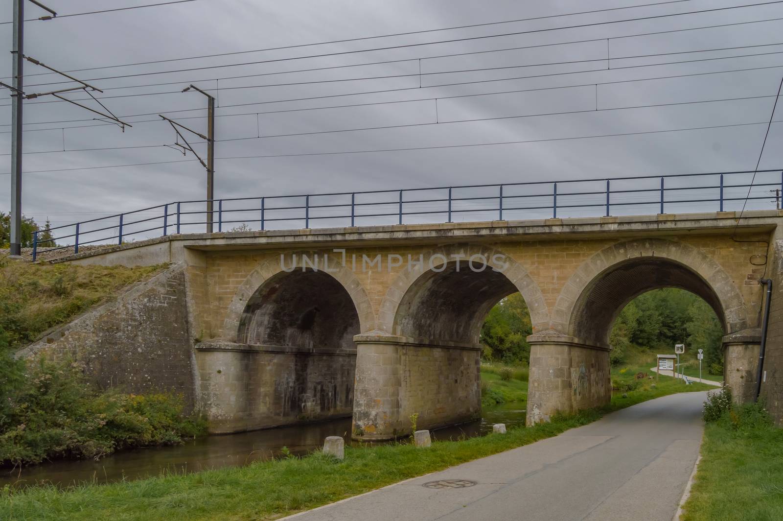 Railway bridge with three arches, two for the river of the tone and one for the tarmaker road in the city of Virton in the province of Luxembourg in Belgium