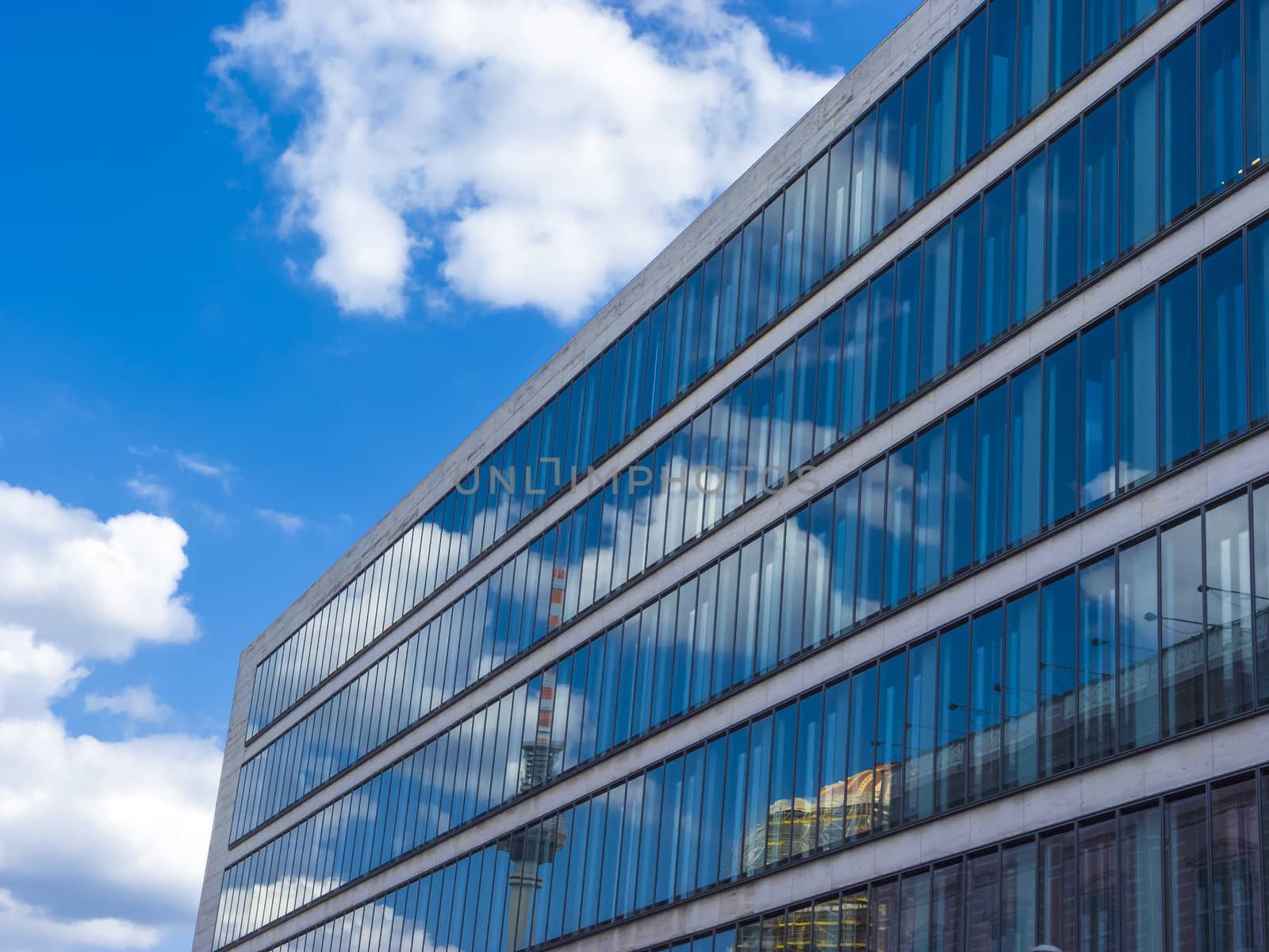 Cloudy sky reflected in the glass wall of a high building by ankarb