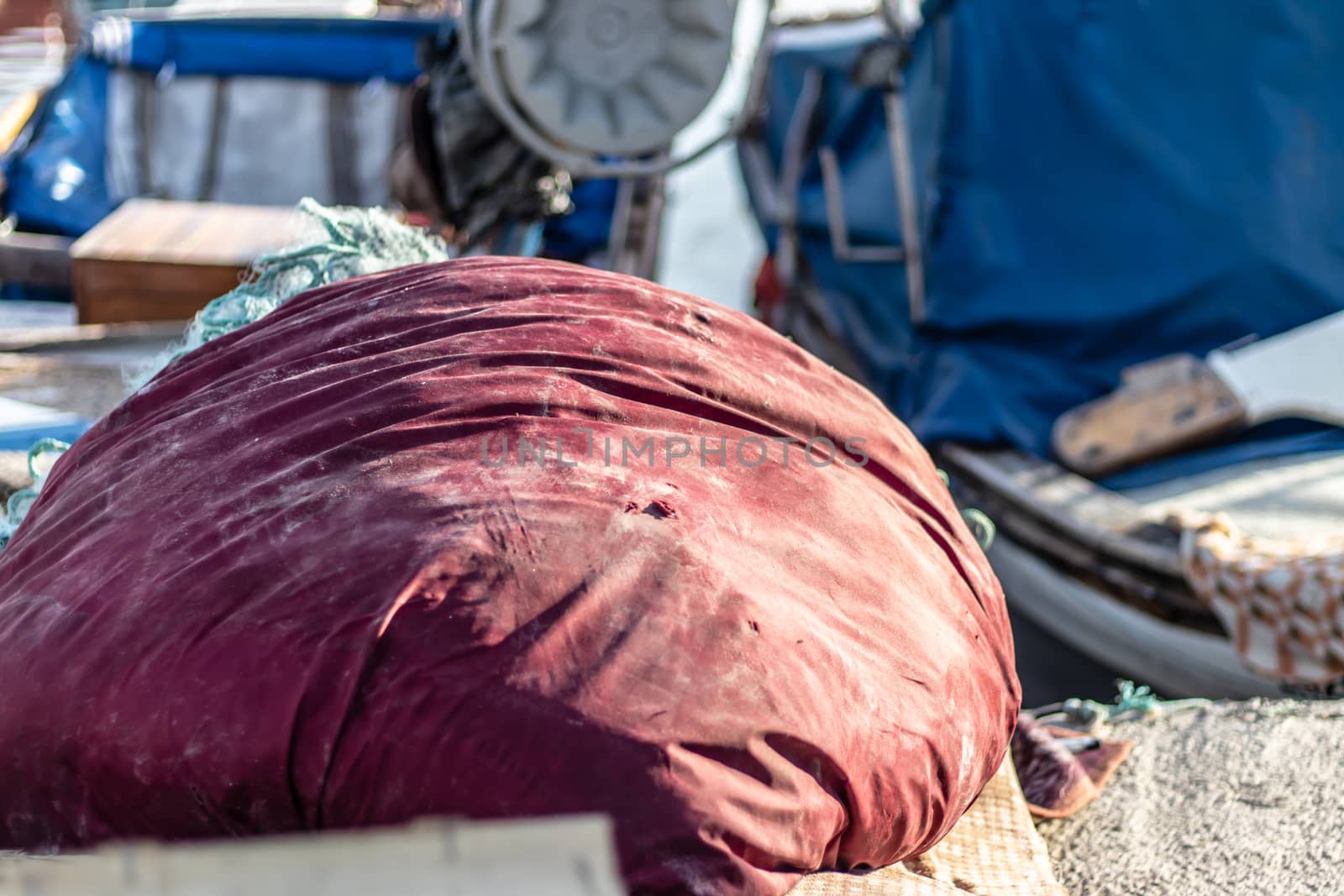 some garbage with red sack next to a boat at fisherman bay. photo has taken at izmir/turkey.