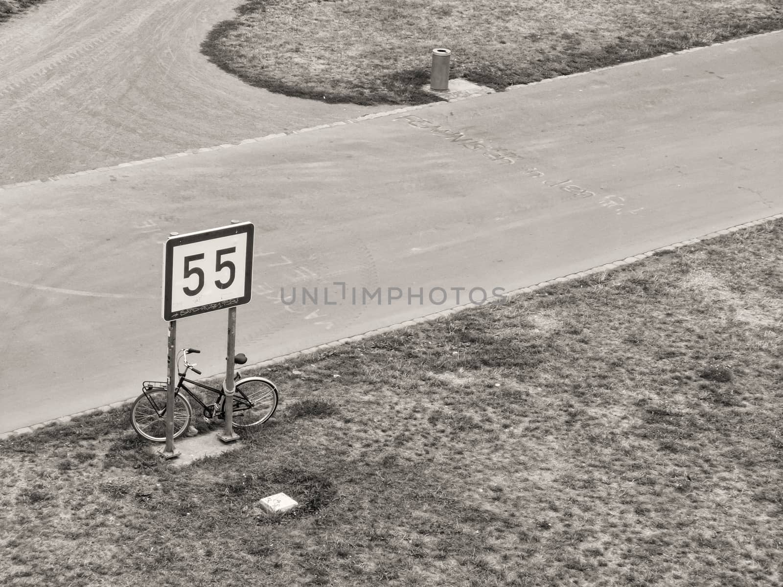 Bicycle parked under a road sign. by ankarb