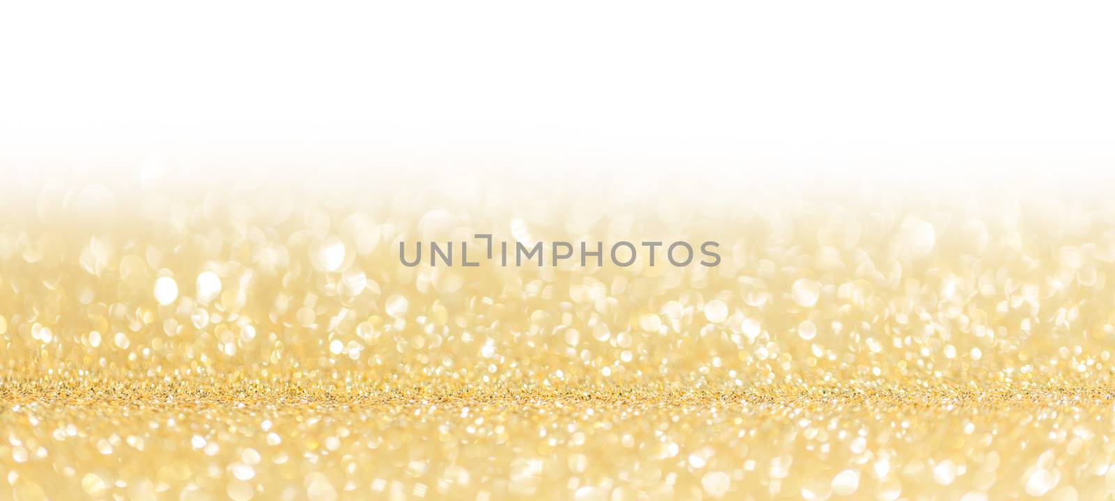 Golden festive glitter background with defocused lights , white copy space