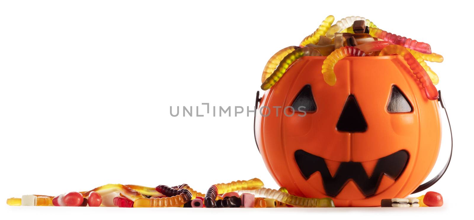 Sweets gummy worms candies in Halloween bag basket jack o lantern pumpkin isolated on white background