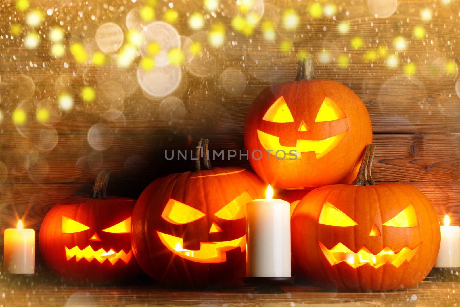 Magic halloween pumpkins and burning candles and golden bokeh lights around