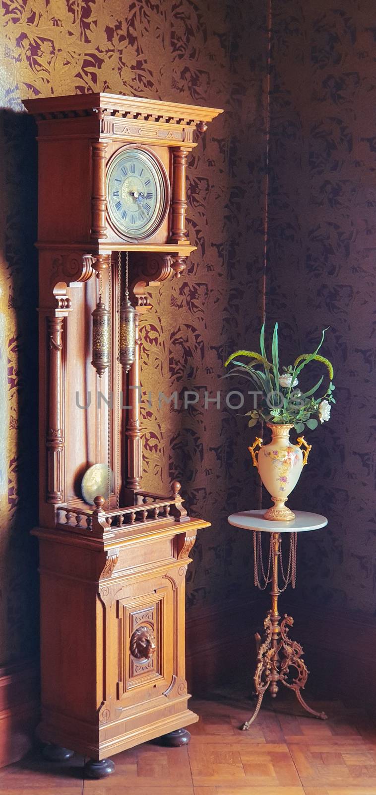 Old fashioned grandfather clock and antique vase by Mendelex