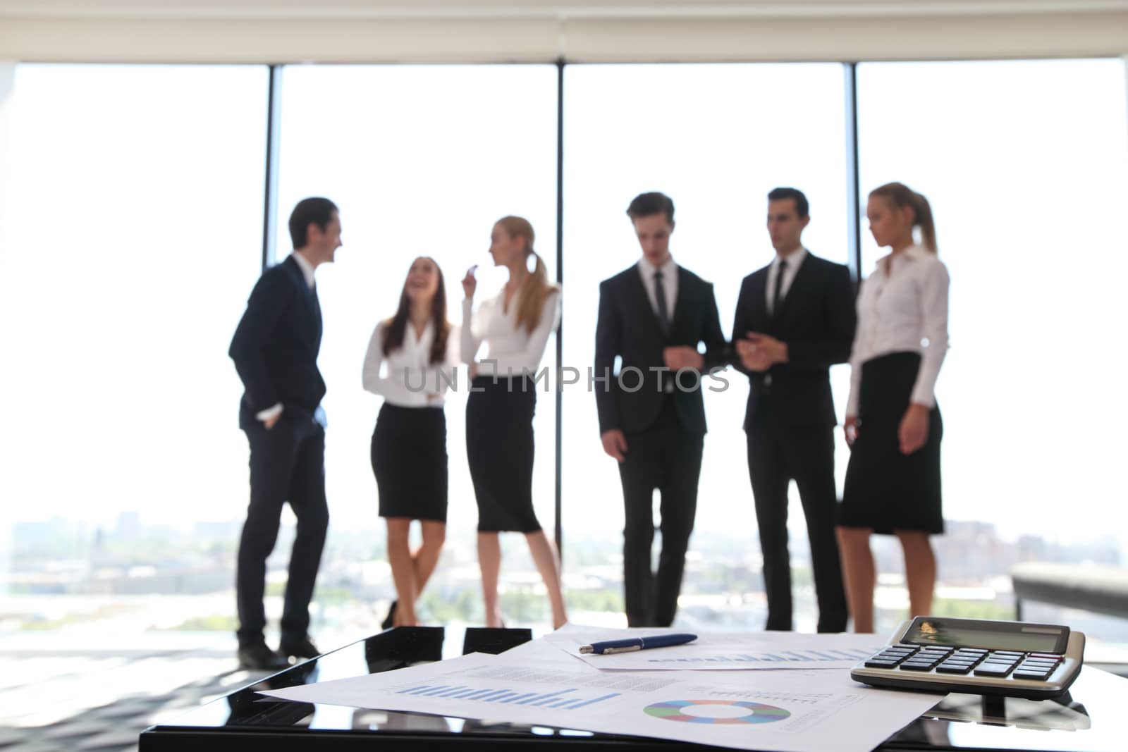 Close up view of printed graphs and business people discussing financial data