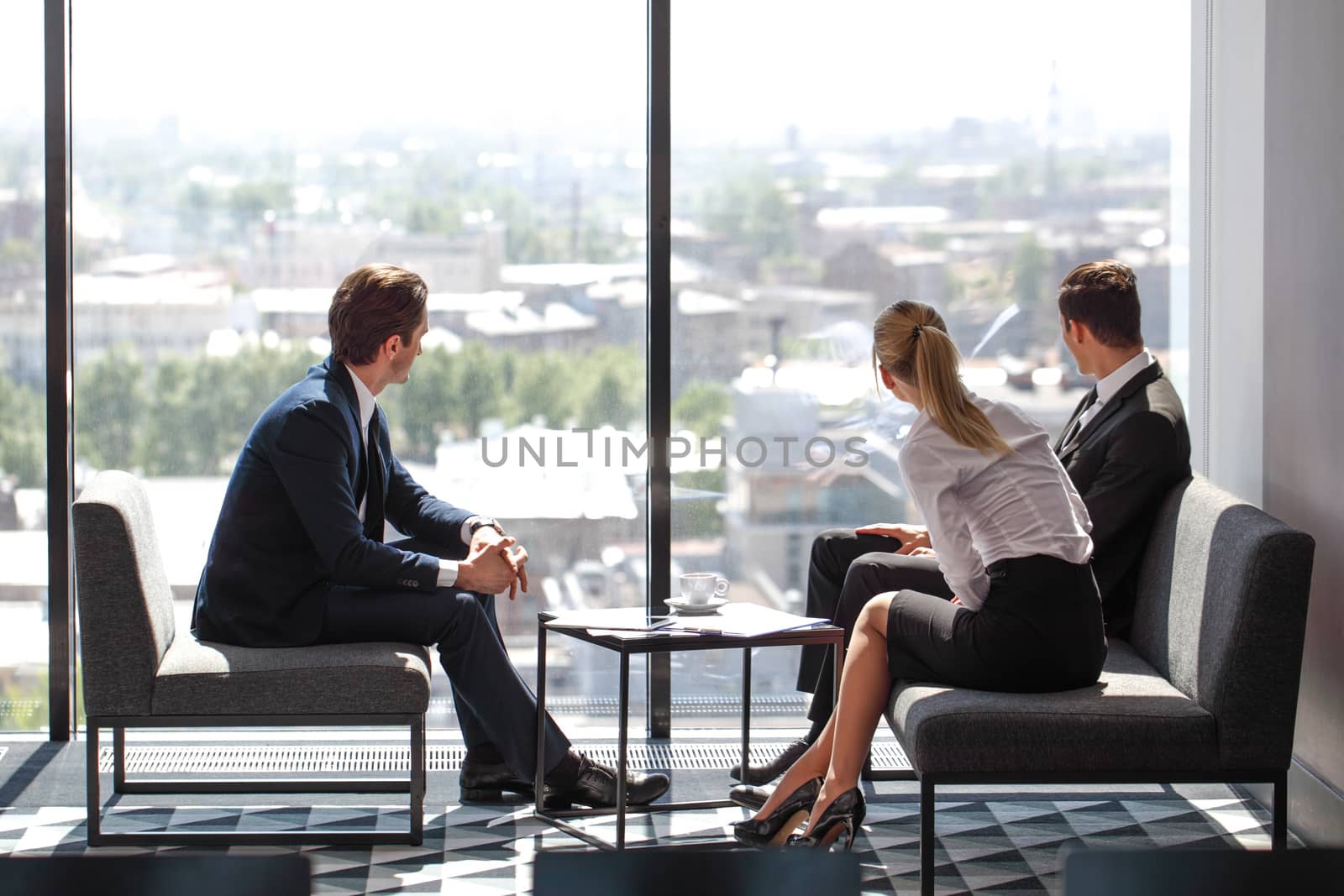 Business people having conversation looking at panoramic window during work break