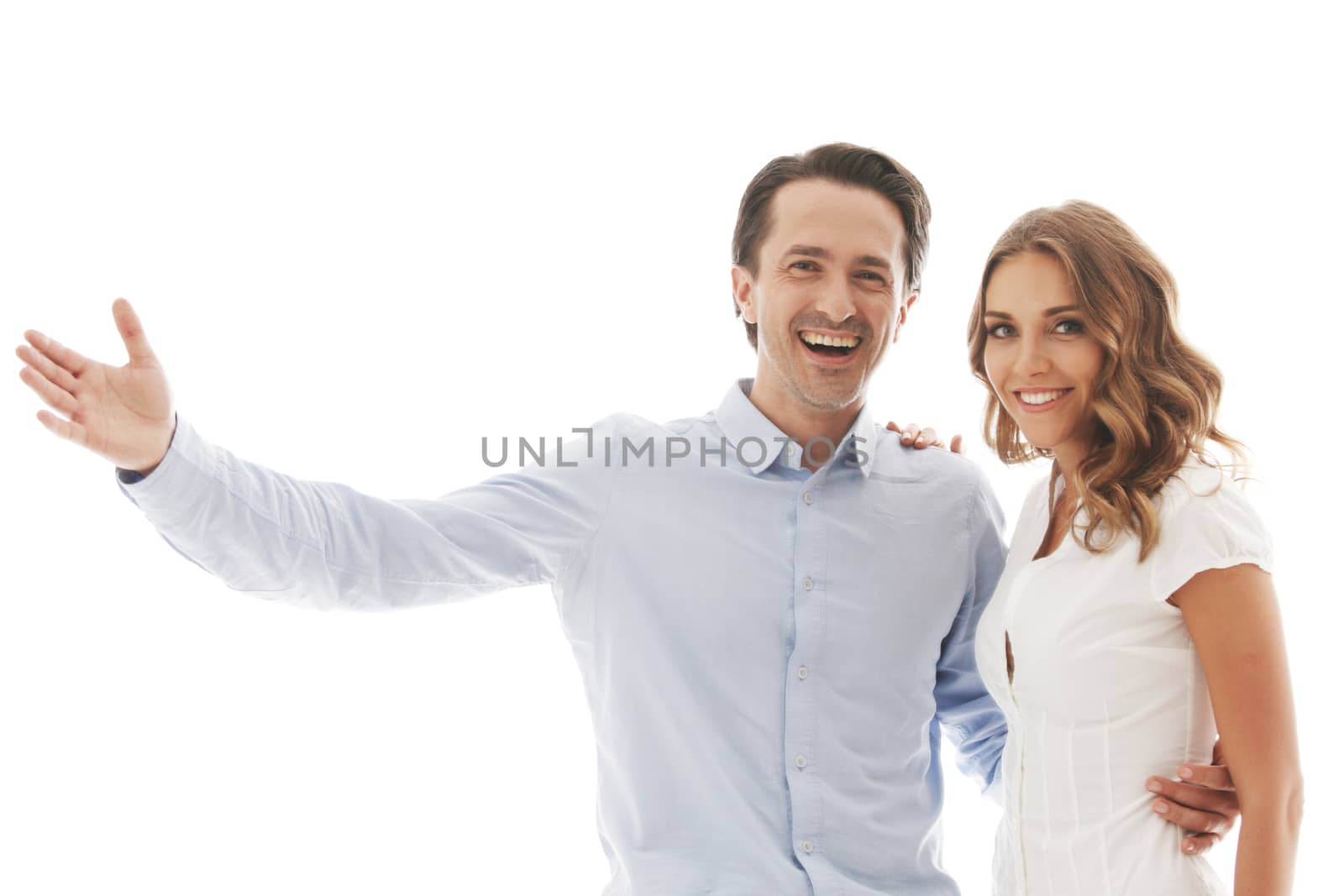Portrait of happy couple isolated on white background, man pointing at white copy space