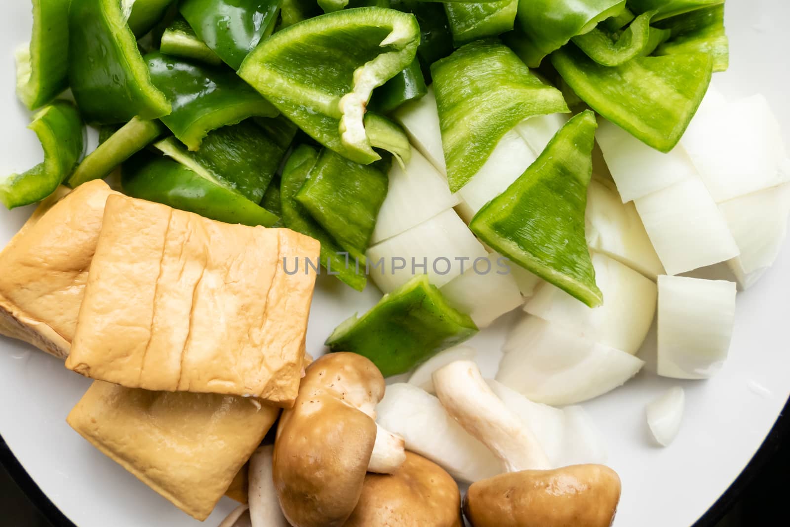Green peppers, tofu, onion, and mushrooms in plate