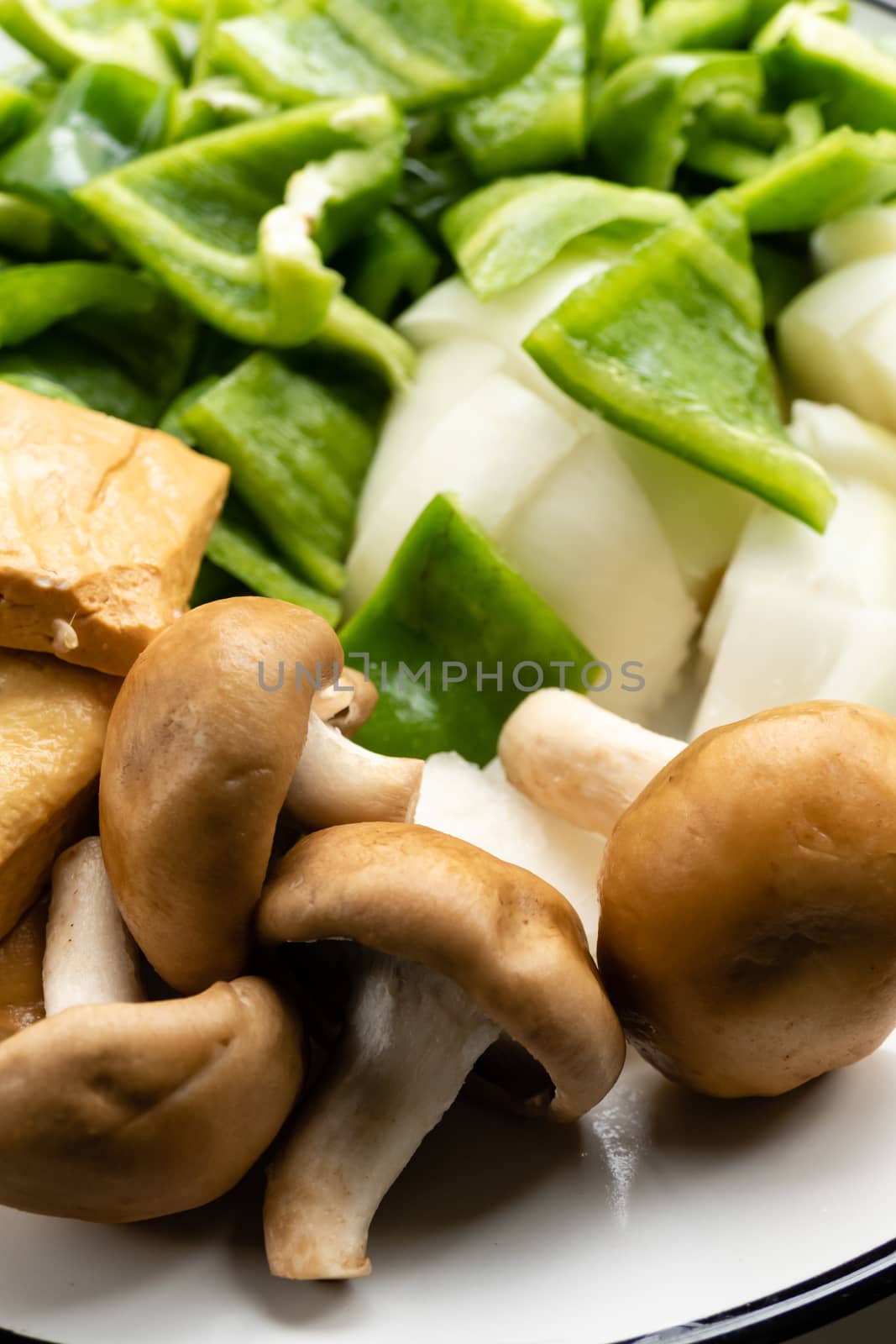 Green peppers, tofu, onion, and mushrooms in plate