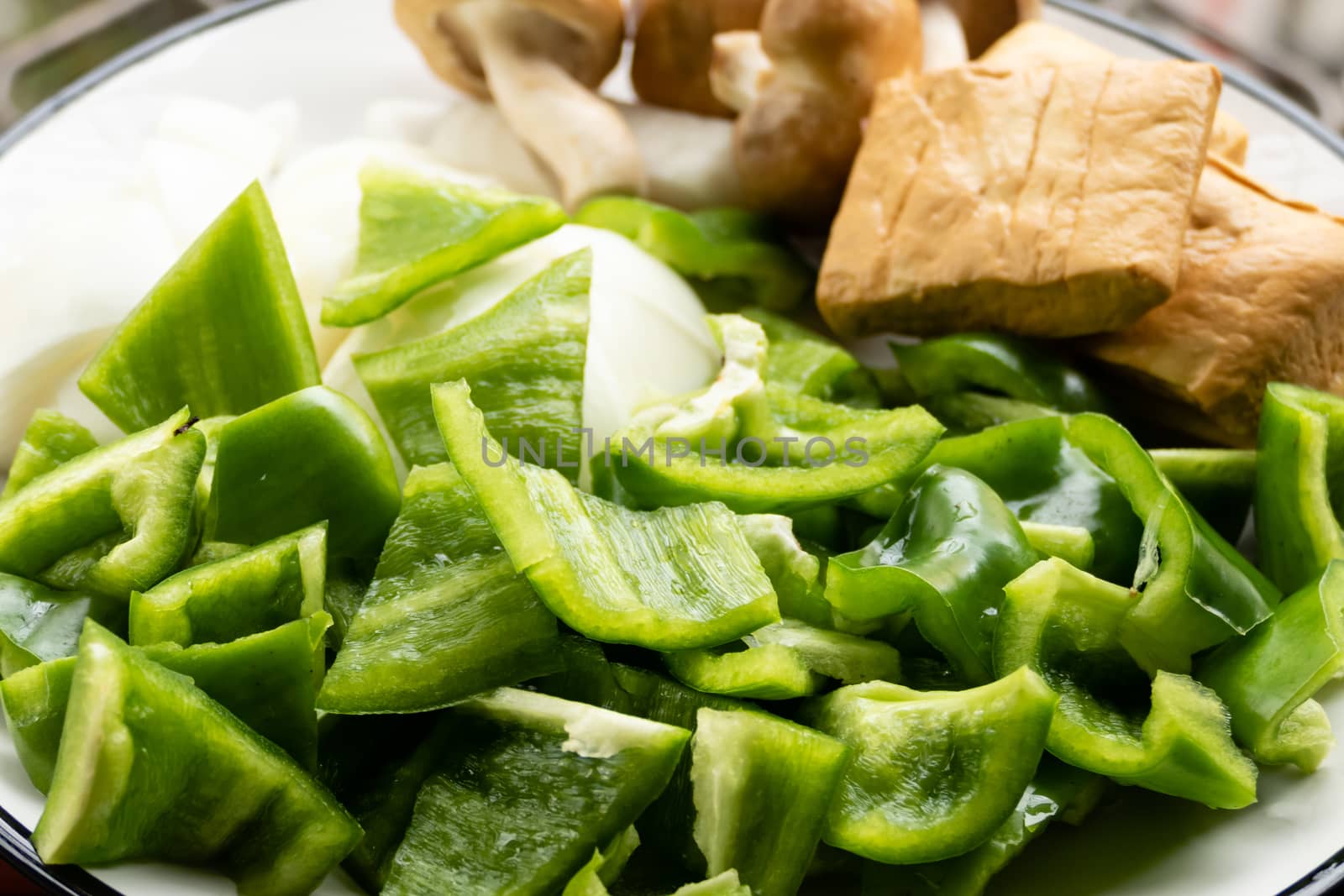 Green peppers, tofu, onion, and mushrooms in plate