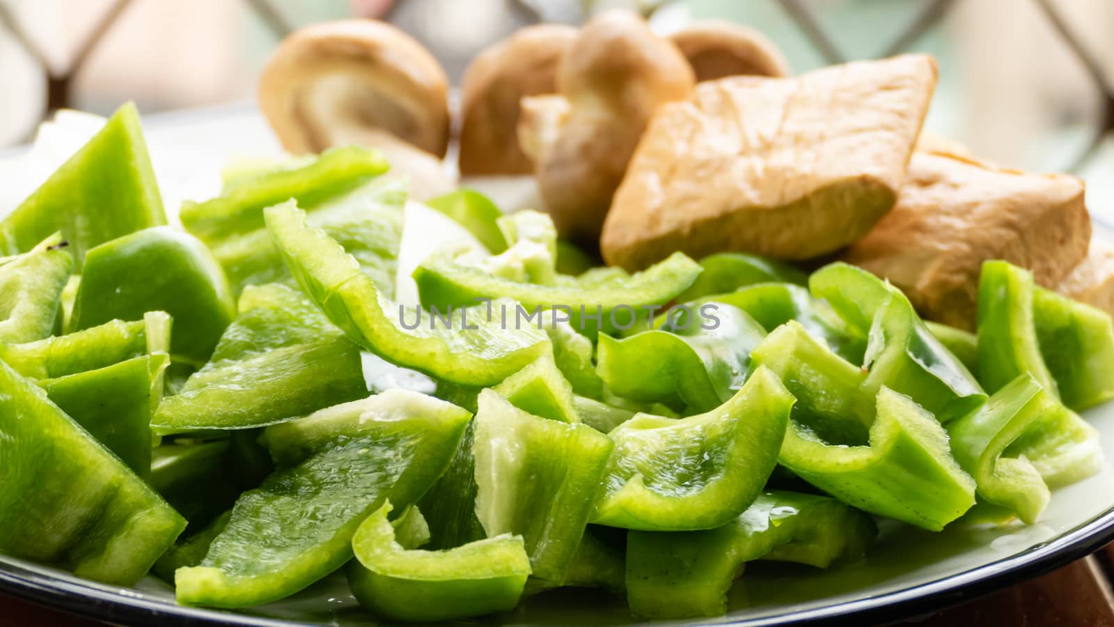 Green peppers, tofu, onion, and mushrooms in plate