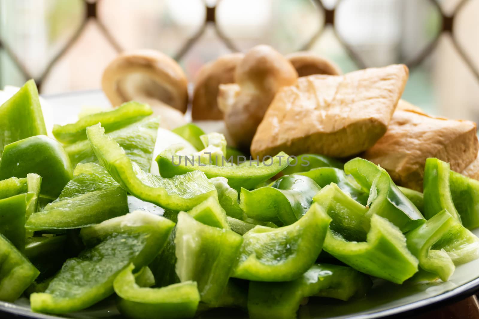 Green peppers, tofu, onion, and mushrooms in plate