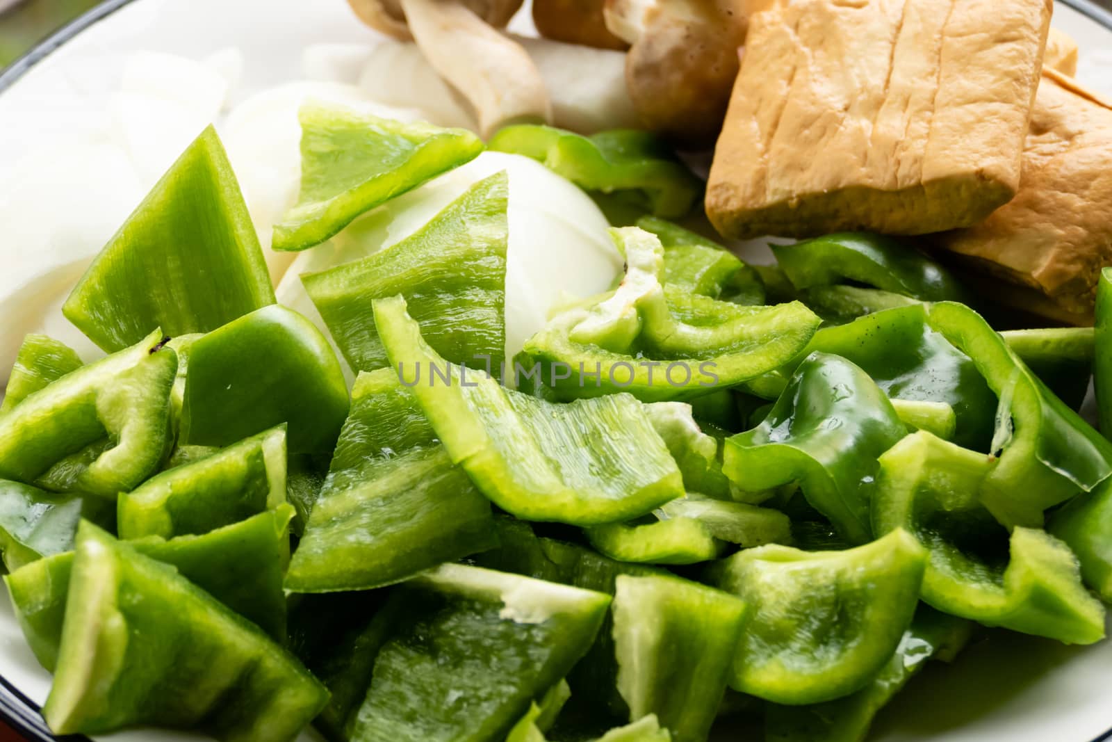 Green peppers, tofu, onion, and mushrooms in plate