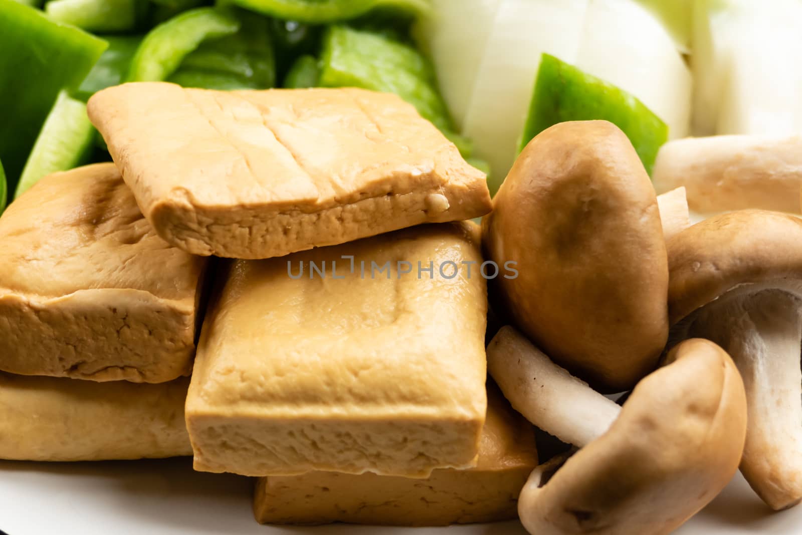 Green peppers, tofu, onion, and mushrooms in plate